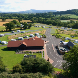 green fields with campervans and motorhomes depicting a caravan park in england