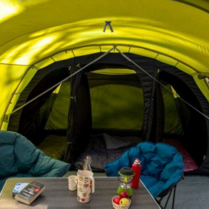 an image taken inside a tent with a camping table and two padded camping tub chairs