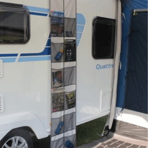 An image showing the side of a caravan with a hanging storage unit filled with caravan essentials