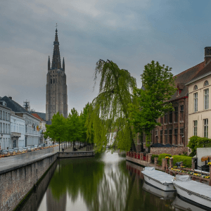 winter camping scene  with a river scene depicting a central river with gothic style houses either side and a large church at the end. 